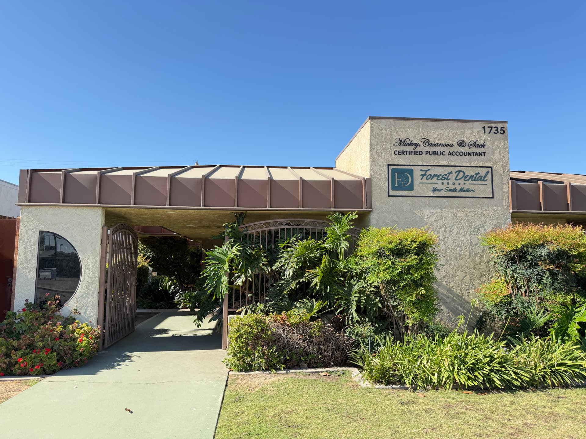 Forest Dental Group exterior entrance with the building sign and landscaped walkway in Bakersfield.